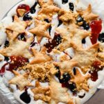 baked pieces of pie crust layered onto berries and cream ice cream.