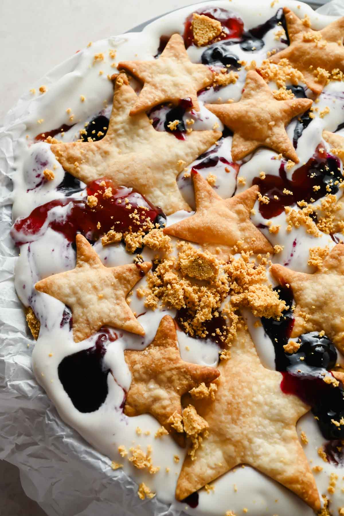 baked pieces of pie crust layered onto berries and cream ice cream.