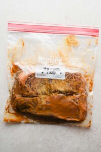 two large steaks marinating in large freezer bag.