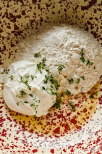 ingredients for cottage cheese biscuit dough in a large speckled mixing bowl.