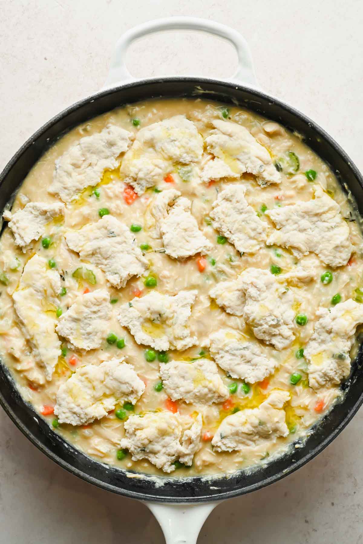 chicken pot pie skillet topped with cottage cheese biscuits in large pan.