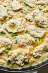 chicken pot pie skillet topped with cottage cheese biscuits in large pan.