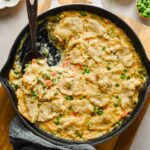 chicken pot pie skillet being scooped out of large pan.