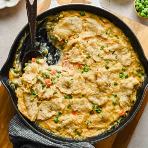 chicken pot pie skillet being scooped out of large pan.