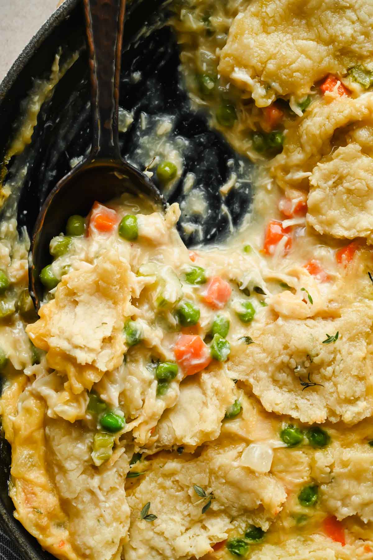 chicken pot pie skillet being scooped out of large pan.