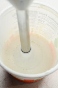 immersion blender in tub of cottage cheese.