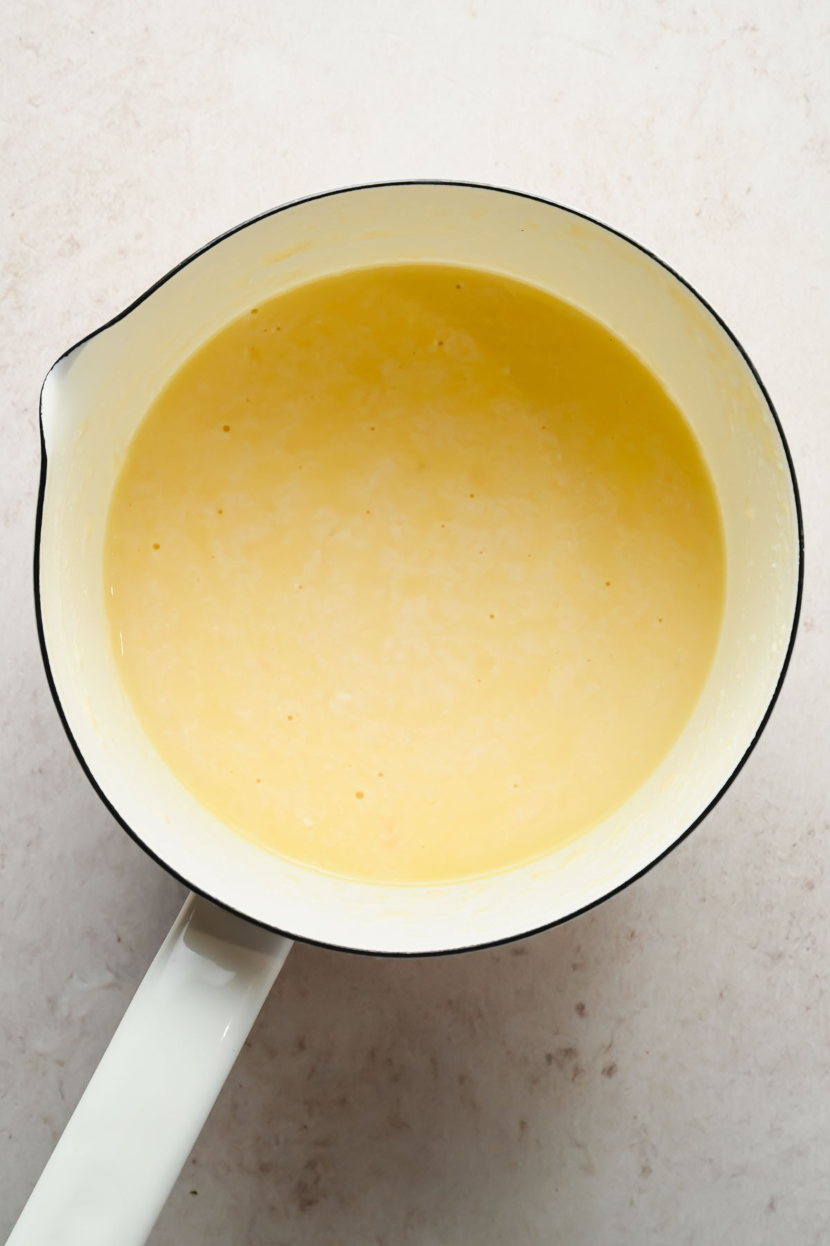 melted cheese sauce in large white sauce pan.